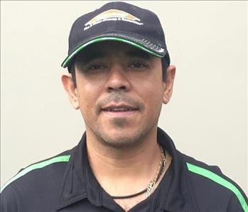 Image of our Project Manager Carlos, male employee with hat on and black shirt
