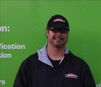 SERVPRO® employee in front of green truck